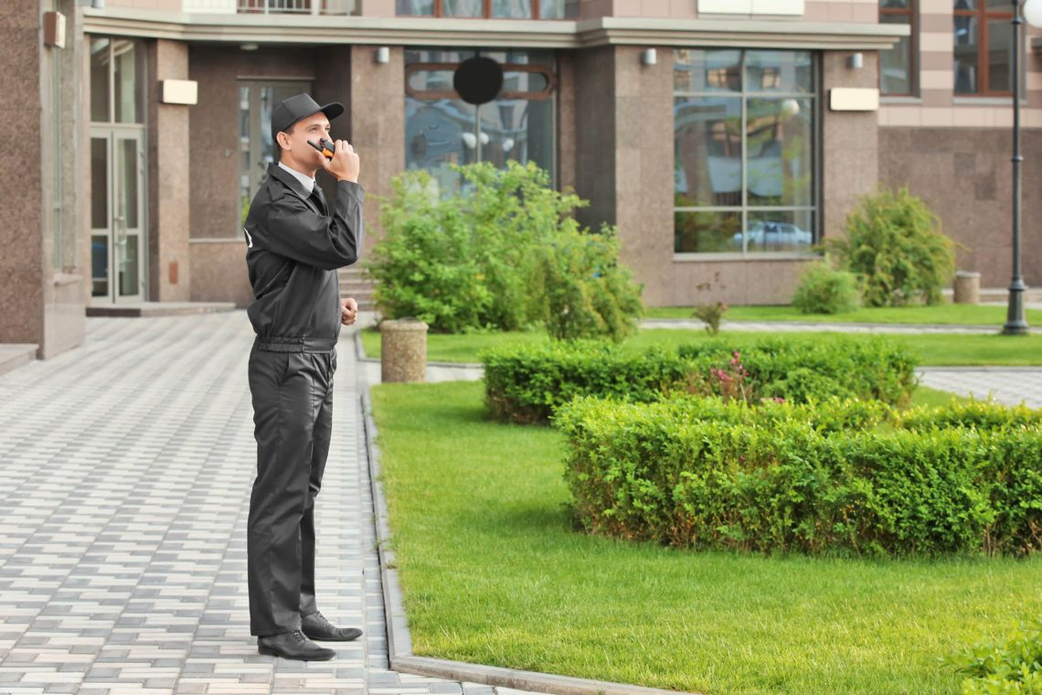 security guard in front of business on portable radio